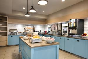 a large kitchen with blue cabinets and food on a counter at Country Inn & Suites by Radisson, Atlanta Airport North, GA in Atlanta