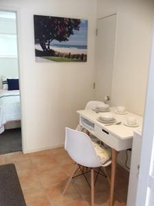 a dining room with a white table and chairs at Albert Mews B and B in Whitianga