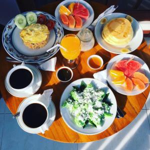 a table with plates of breakfast food and cups of coffee at Maliana Homestay in Munduk