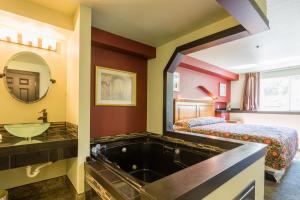 Bay City Inn في بيلينجهام: حمام مع حوض وسرير ومغسلة