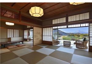 sala de estar con piano de cola y ventanas grandes en Ohito Hotel, en Izunokuni