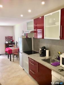 una cucina con armadi rossi e bianchi e un lavandino di Superbe Studio in Nice at 450m from the sea with Clim a Nizza