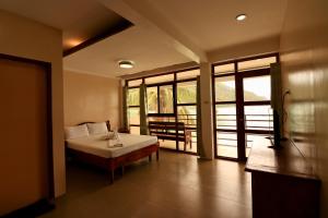 a bedroom with a bed and a large window at Rosanna's Pension in El Nido