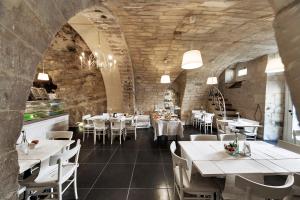 a restaurant with white tables and white chairs at Sabbinirica in Ragusa