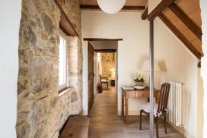 德拉巴新堡的住宿－La Casa di Alice，走廊,位于一栋带石墙和书桌的房子内