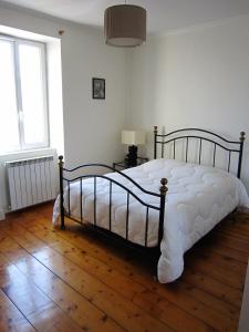 een slaapkamer met een bed en een houten vloer bij Maison de charme à La Rochelle in Croix-Chapeau
