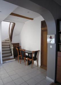 a dining room with a table and chairs and stairs at Maison de charme à La Rochelle in Croix-Chapeau