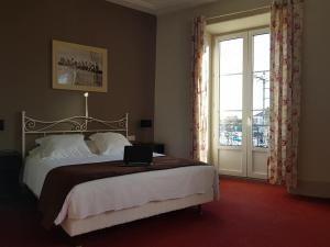 a bedroom with a bed with a laptop on it at Hôtel Bistrot Le Marceau in Limoges