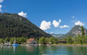 Una vista de un lago con montañas al fondo. en Neuhaus Golf- & Strandhotel, en Interlaken