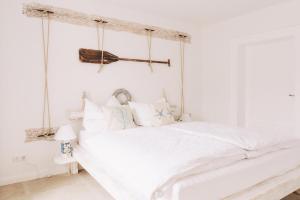 a white bedroom with a white bed with a canopy at Haus Vicus in Greifswald