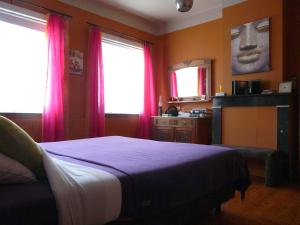 une chambre avec un lit aux draps violets et aux rideaux roses dans l'établissement B&B E48, à Bruges