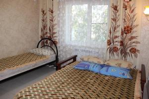2 camas individuales en una habitación con ventana en Holiday Home, en Yeysk