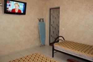 Habitación con TV en la pared y cama en Holiday Home, en Yeysk
