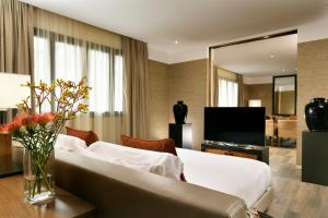 ミラノにあるミラン スイート ホテルのベッドとテレビが備わるホテルルームです。