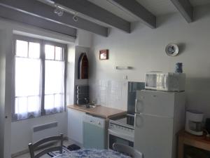 a kitchen with a white refrigerator and a sink at la maison de vincente in Arzon