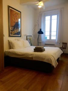 アンティーブにある2 bedroom cool apartment in the old town of Antibesのベッドルーム1室(白いシーツが敷かれた大型ベッド1台、窓付)