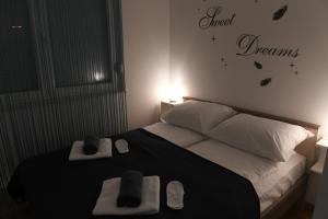 a bedroom with a bed with towels and dreams written on the wall at Oaza Apartman Zagreb Arena 1 in Zagreb