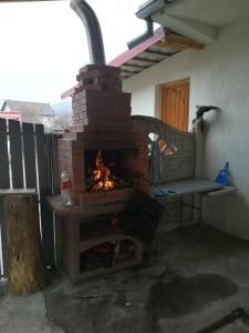 a brick oven with a fire in a patio at Casa Lidia și Gogu in Budeasa Mare