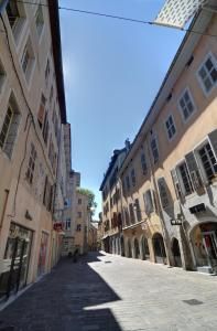 une rue vide dans une ville avec des bâtiments dans l'établissement Les Petits Boudoirs de Savoie, à Chambéry