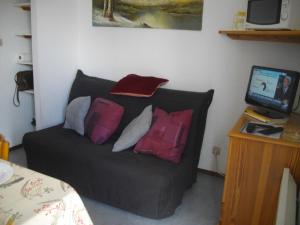 a couch with pillows on it in a room at Les Cretets in Les Rousses