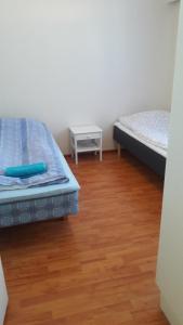 1 dormitorio con 2 camas y suelo de madera en Karijoen Helmi, en Karijoki