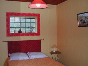 1 dormitorio con 1 cama con cabecero rojo y ventana en Gite les Flots Bleus, en Jullouville-les-Pins