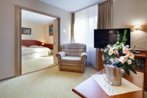 a hotel room with a television and a bedroom at Hotel Wodnik in Łeba