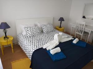 a bedroom with a bed with towels on it at Lila's Beach Apartment in São Roque +26 photos