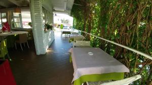 a patio with a table and chairs and plants at Hotel Ristorante Fortuna in Cavallino-Treporti