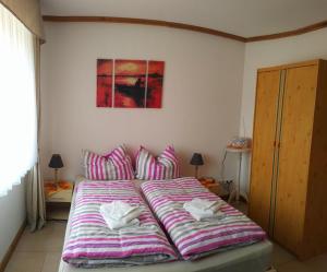 1 cama con sábanas a rayas en un dormitorio en Aaron - Privatunterkunft, en Magdeburgo