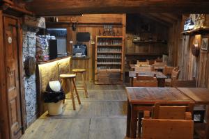 a restaurant with wooden floors and tables and chairs at L'Enventoour in Meleze