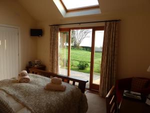 a bedroom with a bed and a large window at The Lodge, at Orchard Cottage in Much Marcle