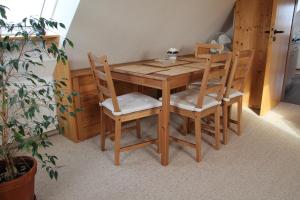 a wooden table with four chairs and a table and a plant at Ferienwohnung Hamberge in Hamberge