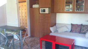 a small living room with a couch and a table at Bonito bungalow con jardín en playa Nerga in Hio