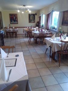 un restaurante con mesas y sillas con manteles blancos en pension sonne, en Ulm