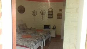 a bedroom with two beds and a tv on the wall at Imka Trinity Retreat in Stormsrivier