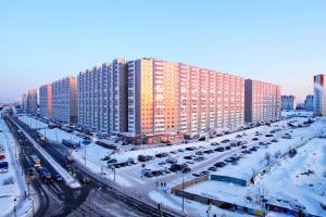 スルグトにあるSurgut Apartments on Krylova 26の駐車場車を停めた大きな建物