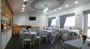 a dining room with white tables and chairs at Carolina Hotel since 1934 in Athens