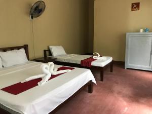 ein Zimmer mit 2 Betten und Handtüchern darauf in der Unterkunft Adventure Camp Beach Resort in Sablayan