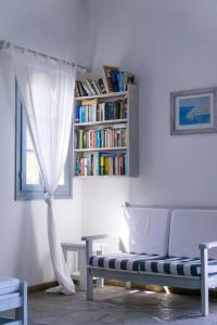 a room with a couch and a book shelf with books at Hotel Manto in Naousa