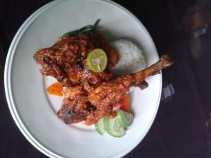 a plate of food with meat and vegetables on a table at Village Corner Homestay in Kuta Lombok +27 photos