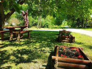 a park with a picnic table and flowers in the grass at Kúti Vendégház in Bakonykúti