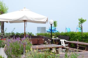 a patio with a table and an umbrella at Affittacamere Porticciolo in Castelnuovo del Garda