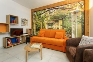 een woonkamer met een oranje bank en een tafel bij Apartment La Maisonnee in Chamonix-Mont-Blanc