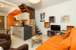 een woonkamer met een oranje bank en een keuken bij Apartment La Maisonnee in Chamonix-Mont-Blanc