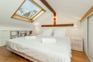 een groot wit bed in een kamer met een raam bij Apartment La Maisonnee in Chamonix-Mont-Blanc