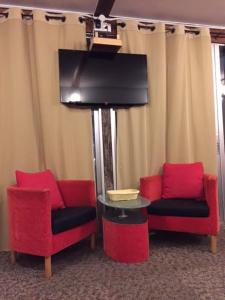 een kamer met 2 stoelen, een tv en een tafel bij Rumah Kurnia in Kangar