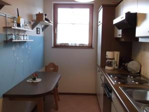 eine kleine Küche mit einem Tisch und einem Fenster in der Unterkunft Pension Elisabeth in Sankt Kanzian am Klopeiner See