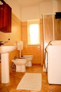 un bagno con un lavandino, un water e un lavandino di La Casa Gialla a Moneglia