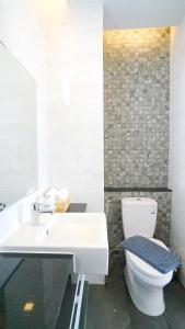 uma casa de banho com um WC branco e um lavatório. em APA-TREE Boutique Hotel em Praia de Natai